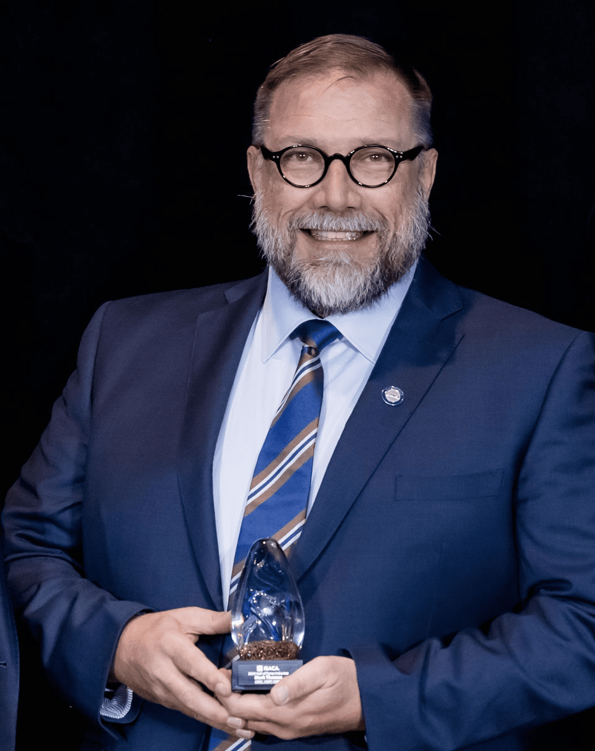 Mark Thomas governance and risk advisor portrait holding award